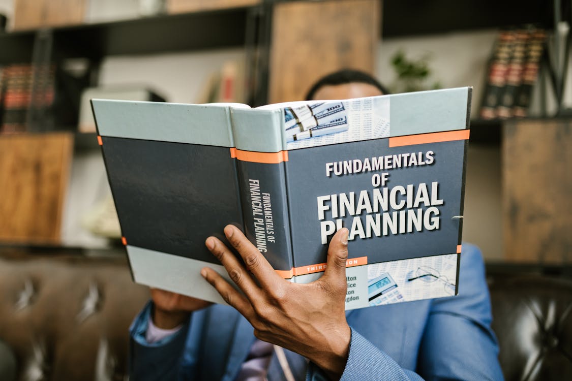 Person reading a financial planning book — best personal finance books 2026