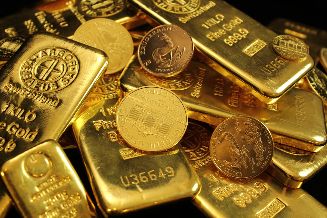 Close-up of gold bars and coins — how to invest in gold 2026