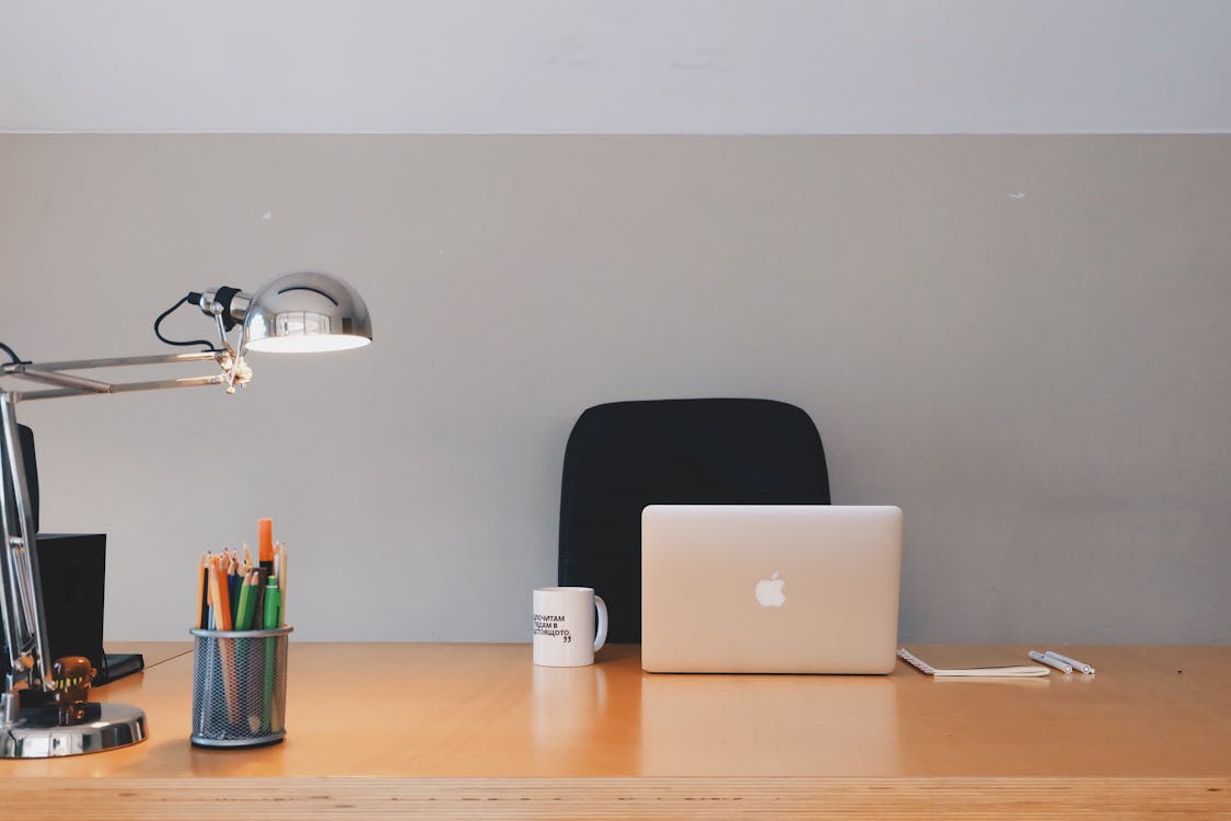 Silver Apple MacBook on wooden desk — MacBook Air workspace 2026