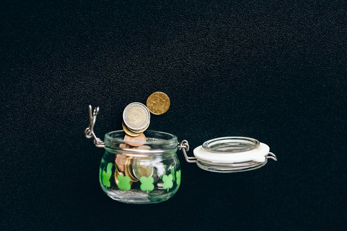 Coins in jar representing compound retirement savings growth 2026