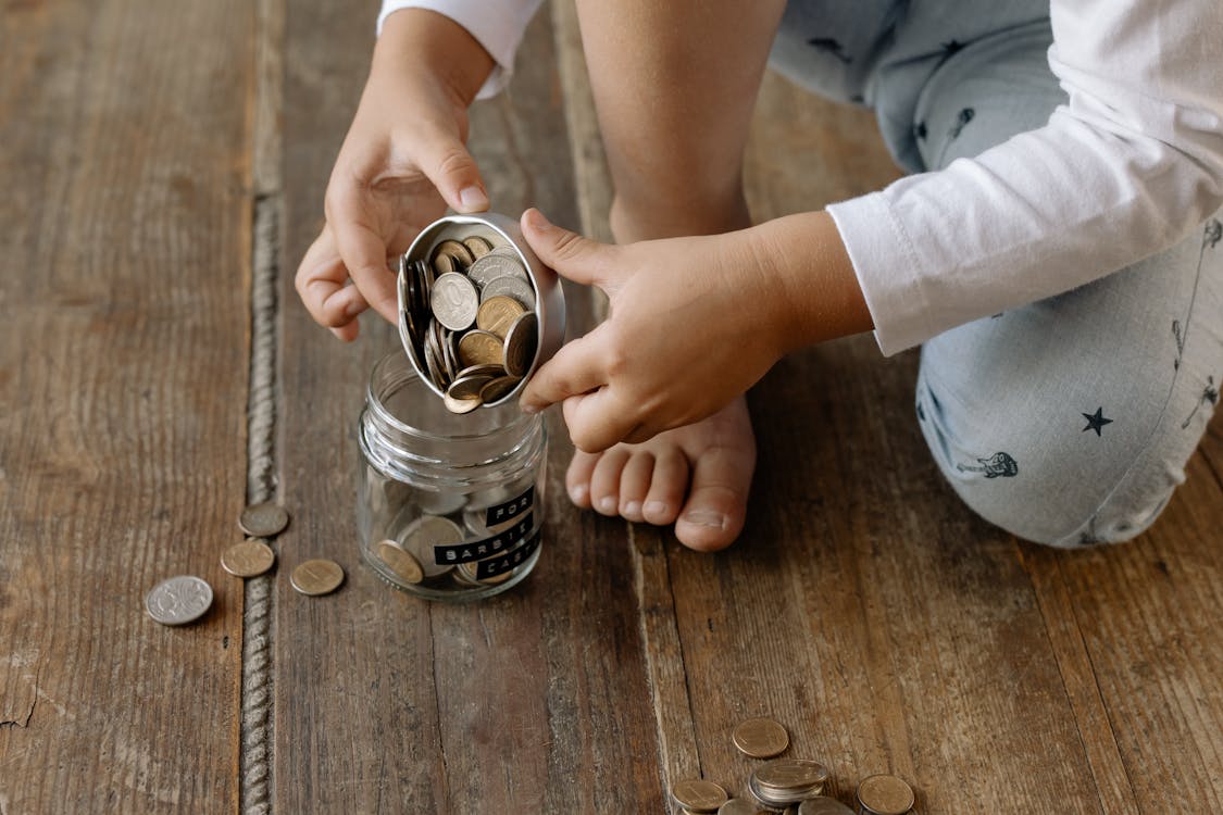 Person putting coins into savings jar — Roth IRA vs 401k retirement planning 2026